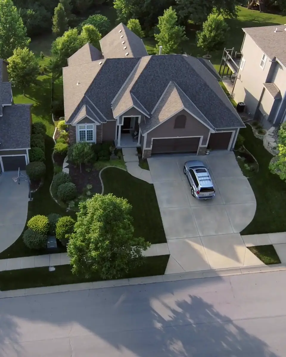 Aerial view of two-story suburban homes with driveways and green lawns